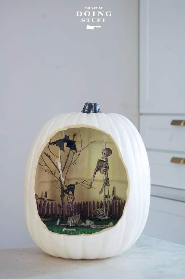 A hollow foam pumpkin with an entire graveyard scene including skeletons and bats inside.