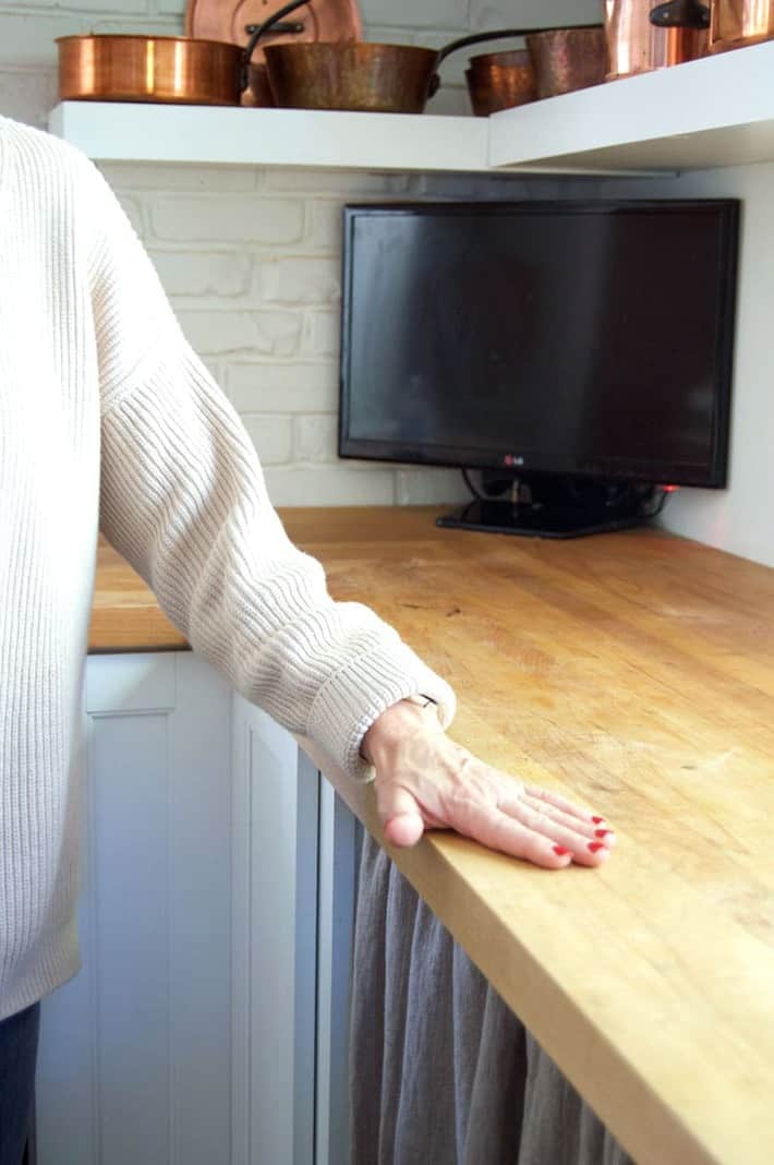 Running a hand along a wood counter to make sure it's perfectly clean.