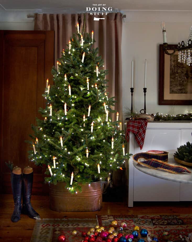 Balsam fir Christmas tree lit with flameless candles in English country inspired room.