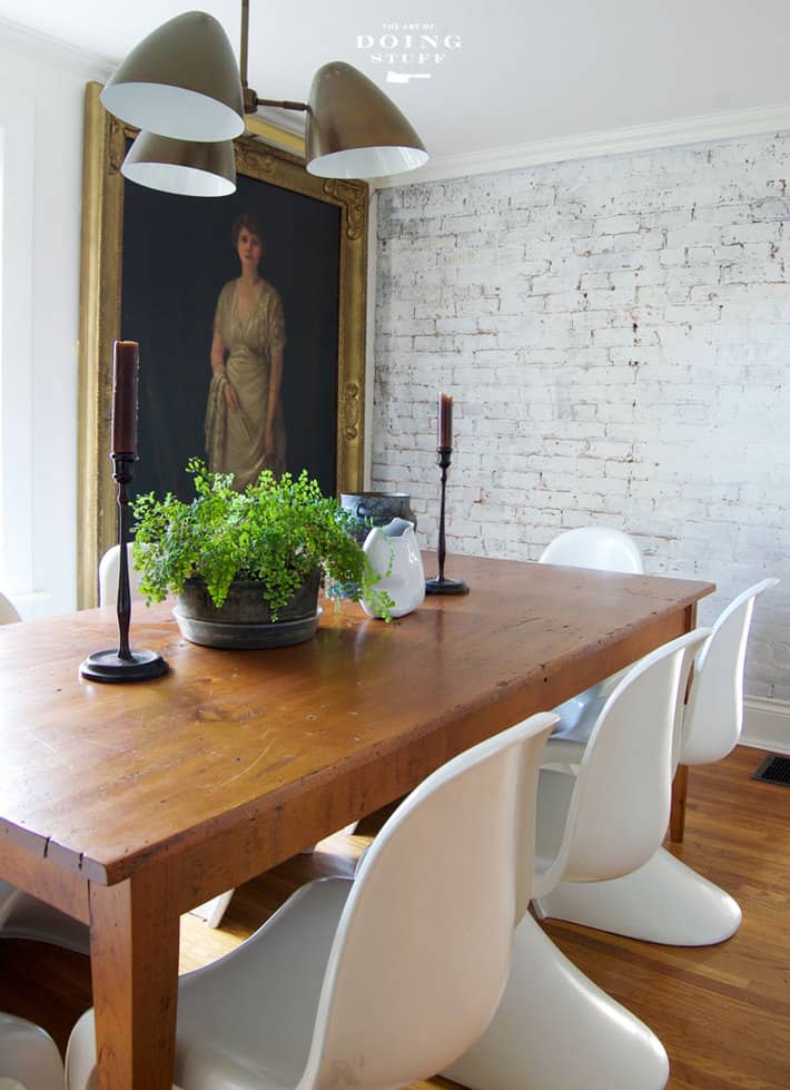 antique life sized portrait against white brick wall.