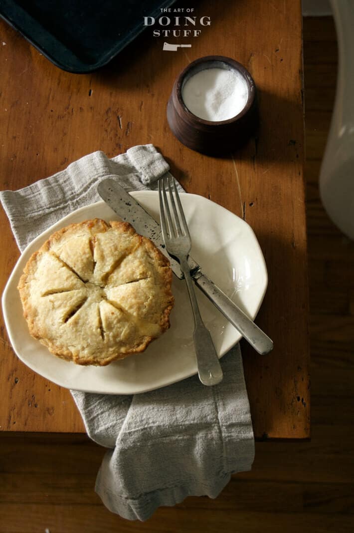 Hot from the oven turkey pot pie set on antique harvest table.