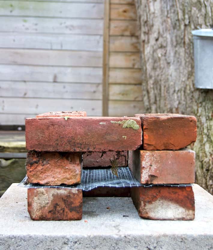 A rocket stove at the beginning of assembly with 3 layers of bricks.