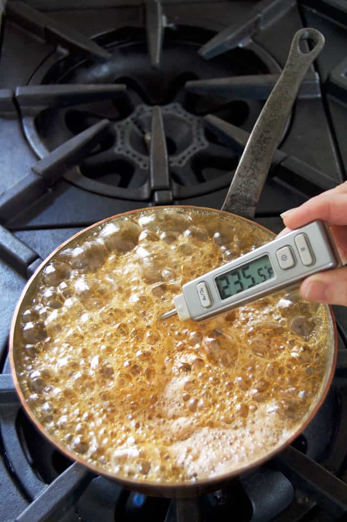 Thermometer reading 235 in pot of boiling maple syrup.