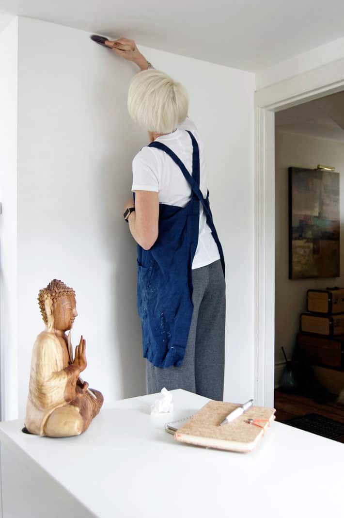 Karen Bertelsen cutting in, painting her office wall with whiteboard paint.