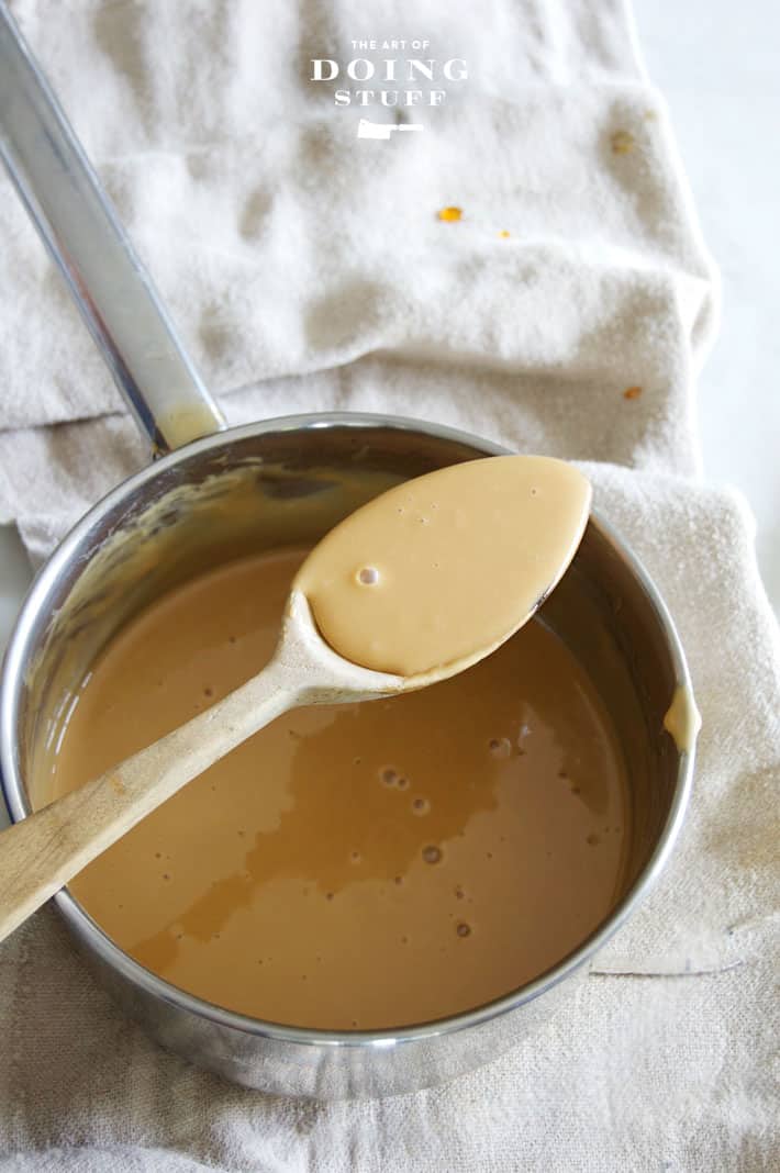 Very light coloured maple cream on a wood spoon.