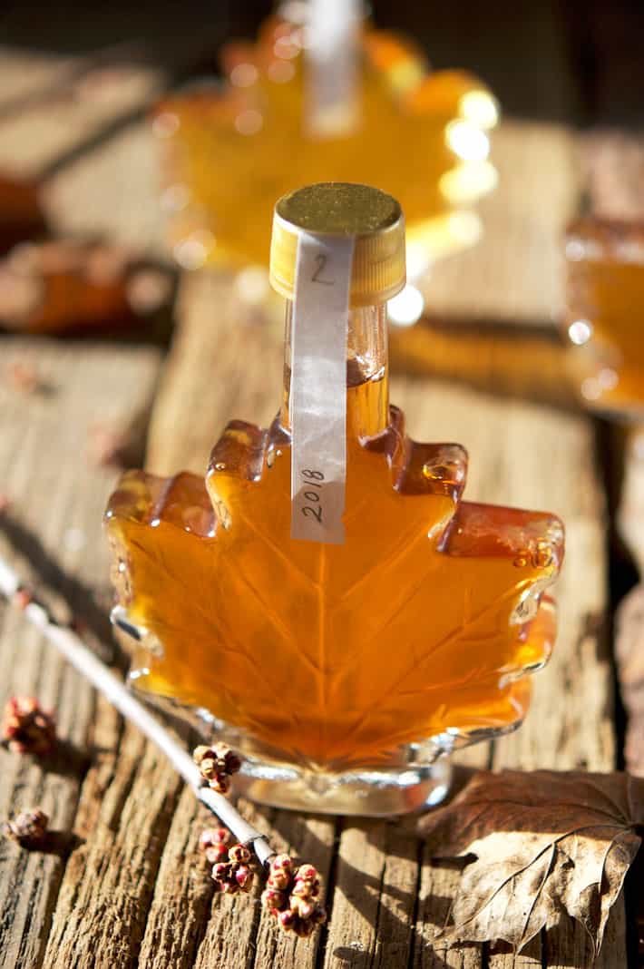 Light shining through bottle of amber maple syrup.