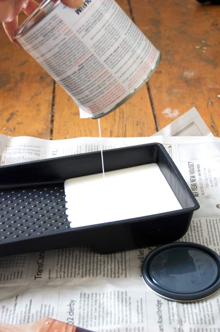 Paint an entire wall in your room or office with whiteboard paint. Here's how. White paint dripping into small black paint tray.