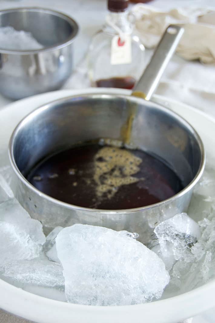 Maple syrup filled pot surrounded by chunks of ice taken out of sap buckets.