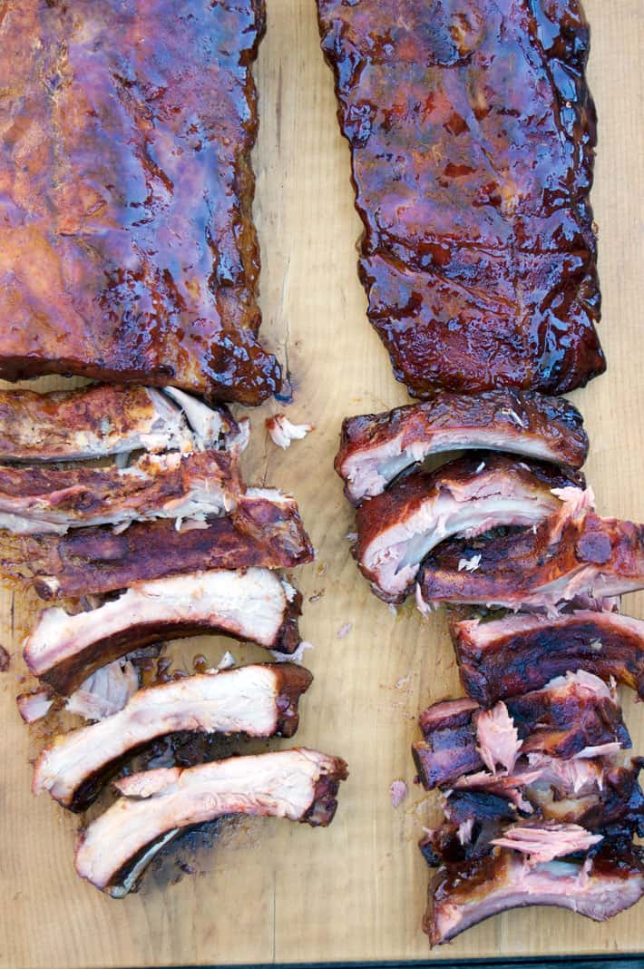 Cut cooked ribs. Rib meat on the left rack is white. Rib meat on the right rack is pink.