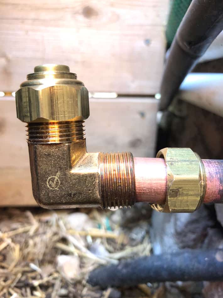 Compression fitting nut slid onto copper pipe ahead of compression elbow fitting.