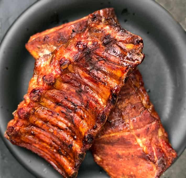 Overhead shot of 2 racks of smoked ribs with beautiful golden colour and bark.