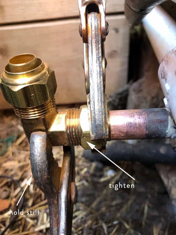 Tightening compression fitting with two wrenches.