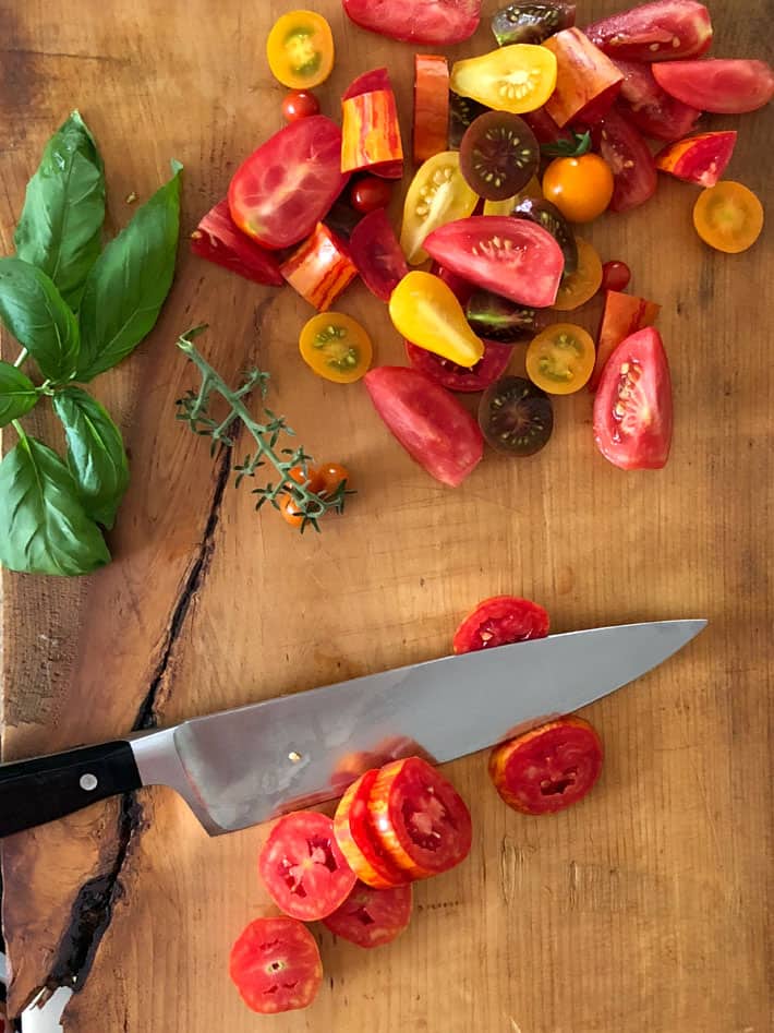 Chopped heirloom tomatoes on wood cutting board.