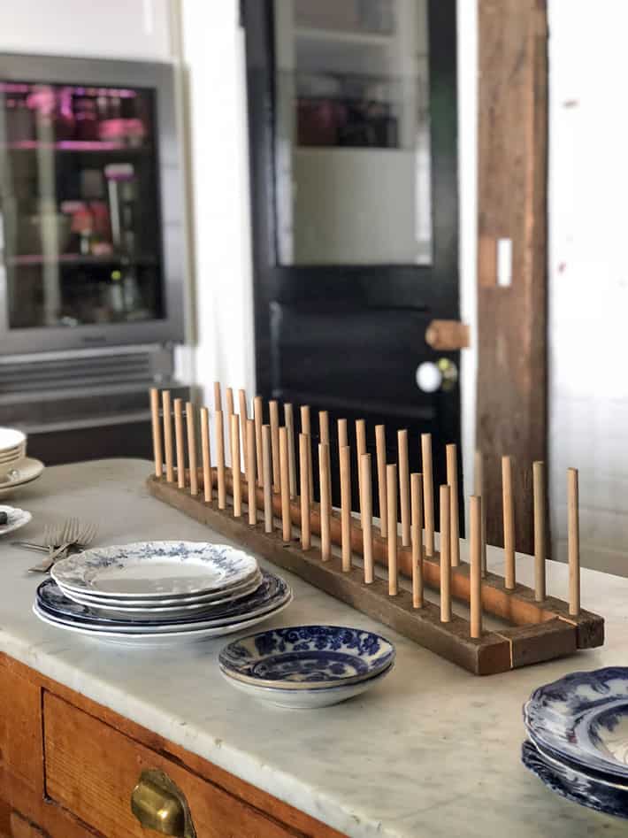 DIY plate rack made of barn board on antique marble kitchen island.