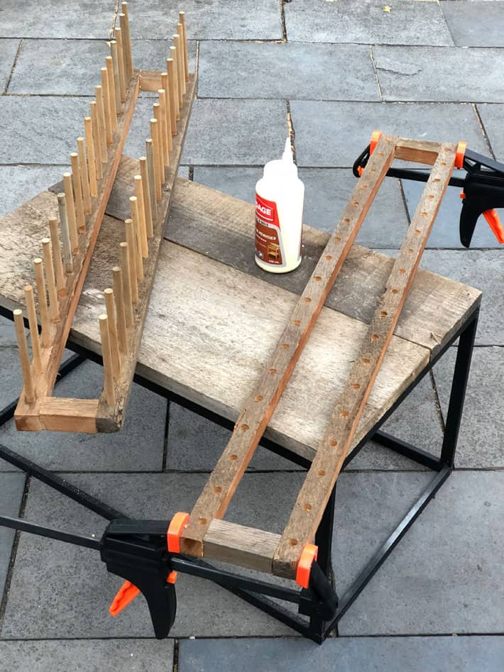 Almost assembled plate racks on table outside being glued and clamped.