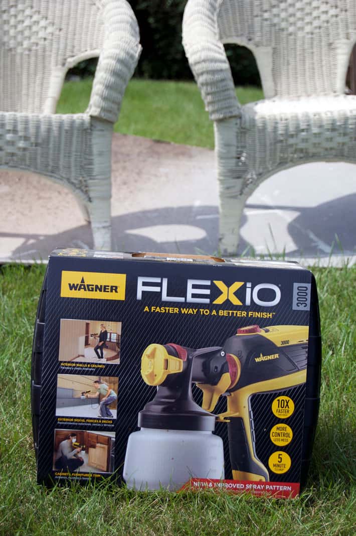 Wagner Flexio 3000 in box sitting on lawn with white wicker chairs in background.