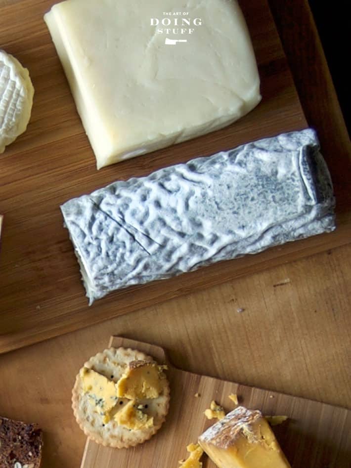 Raw goat cheese seen from above among other chunks of cheeses.