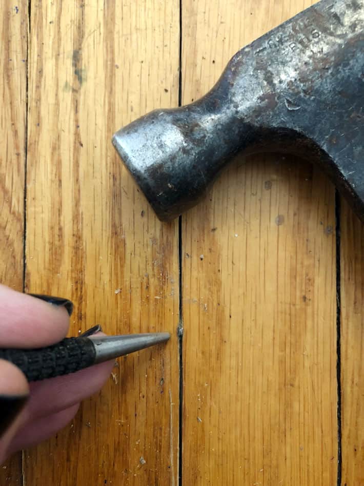 Countersinking nail in hardwood.