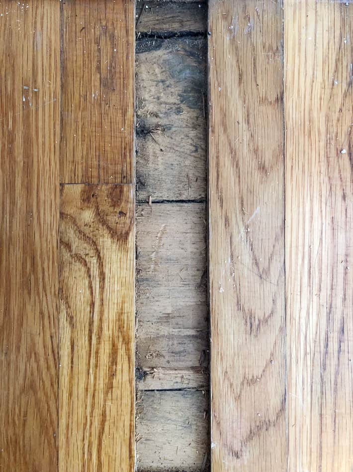 Close up of pine flooring revealed under oak flooring.