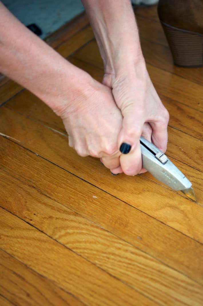 Cutting through oak tongue and groove strip flooring crack to remove single piece.