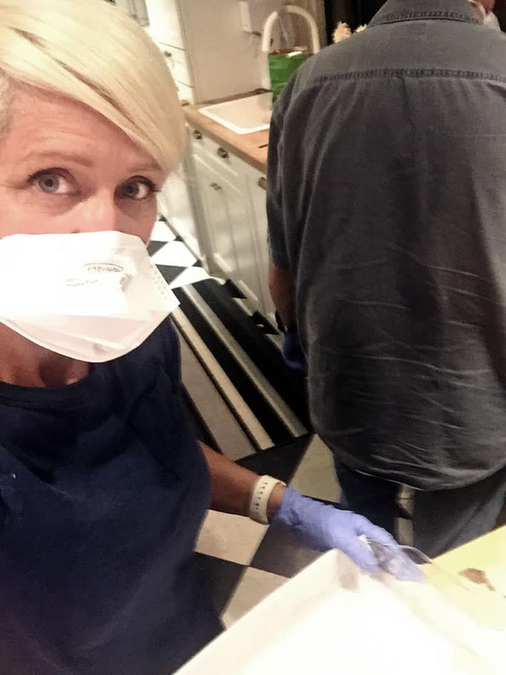 Karen Bertelsen in respirator mask in kitchen.