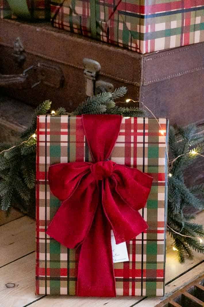 Christmas gift wrapped in plaid paper with a slouchy red velvet ribbon.