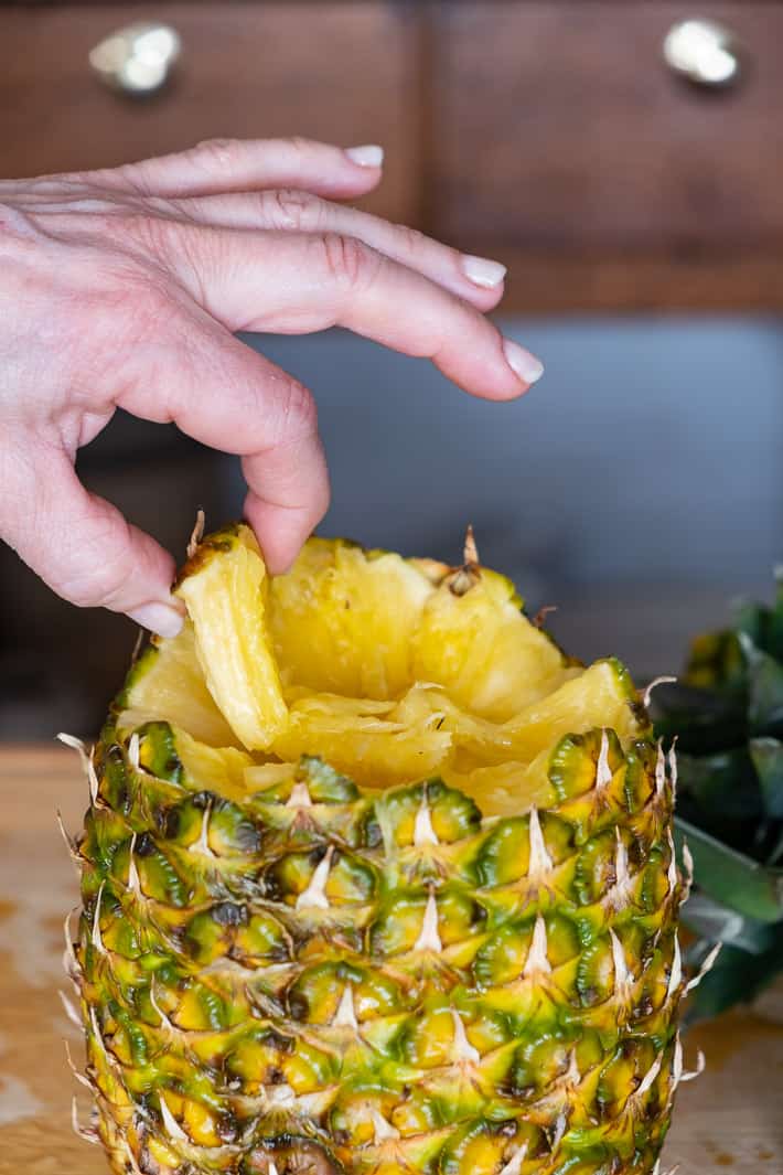 2 fingers pulling away a piece of pineapple.