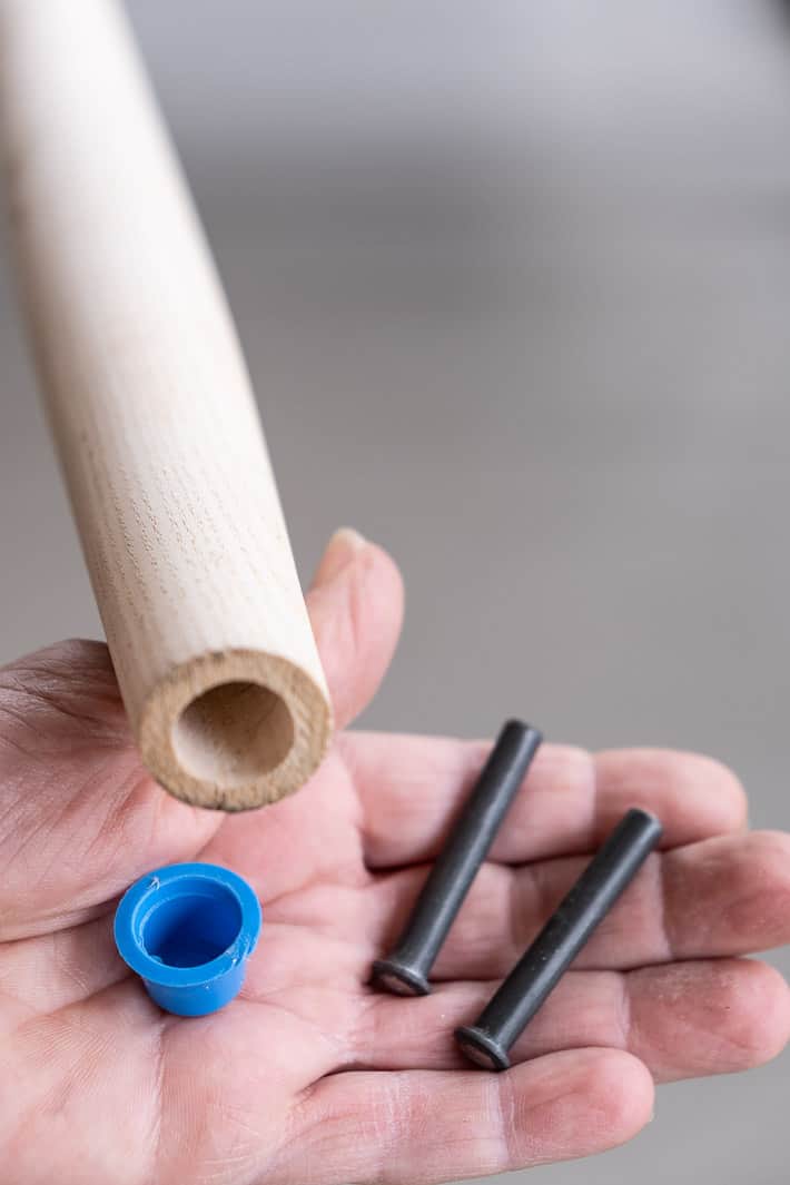 How to replace a broken shovel handle. Don't worry. It's easy. New shovel handle with a blue rubber cap removed that covers a discrete hole in the top of the handle that holds two rivets.