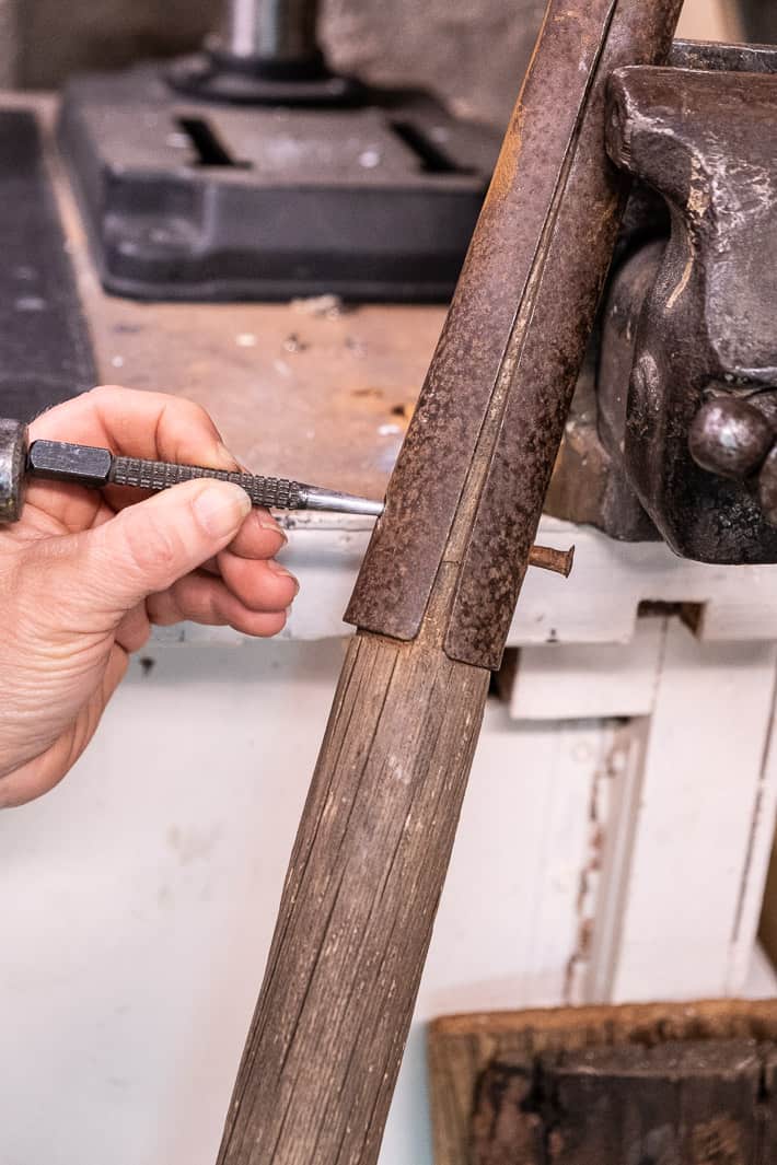 Punching through a rivet from old, rusted shovel head to remove old handle.