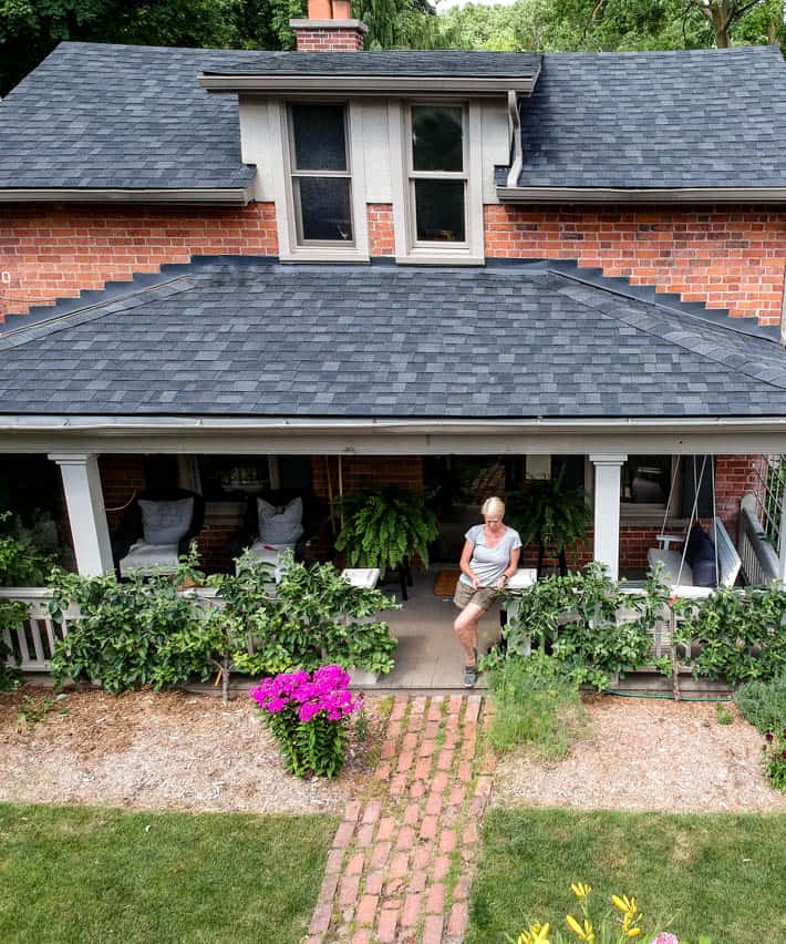 Karen Bertelsen on the front porch of her historic red brick cottage.