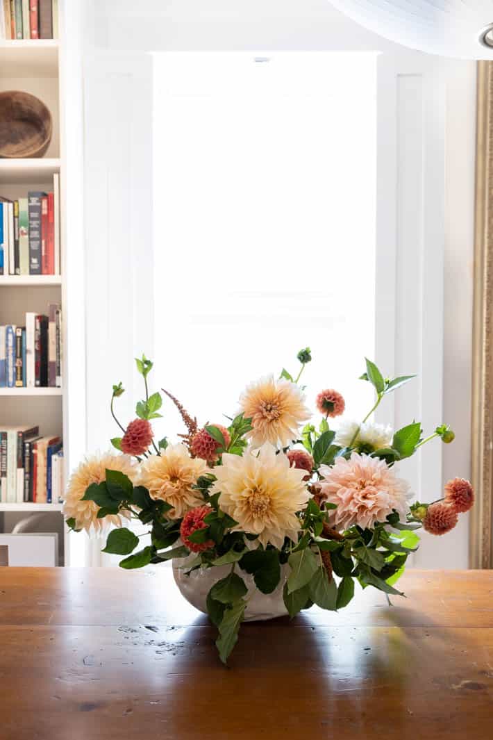 Large flower arrangement of peach and coral dahlias.