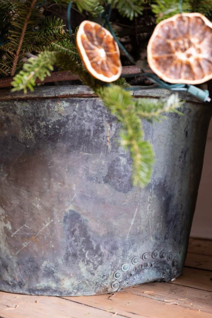 Very large antique copper pot with rivet repair on the bottom.