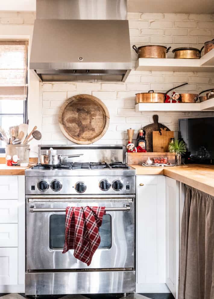 Blue Star range with red plaid towel hanging off the door and vintage red Christmas elves on the counter.