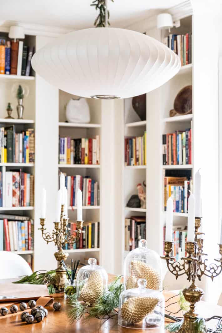 Nelson bubble lamp over harvest table with ornate gold candelabras.