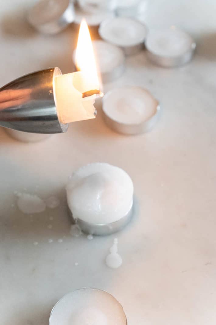 Sealing the bottom of tea lights with a dripping candle.