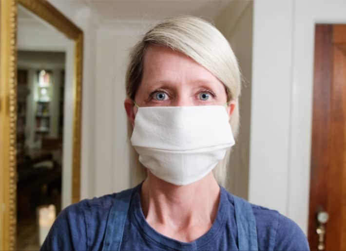 Karen Bertelsen wearing a white napkin turned into a no-sew face mask for blocking some particulate matter.