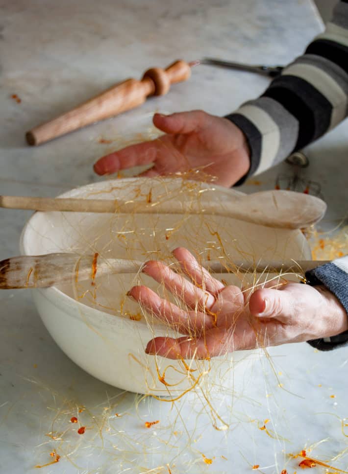 Hands gathering up spun sugar to form it into a ball.Make spun sugar with sugar, water and 15 minutes.