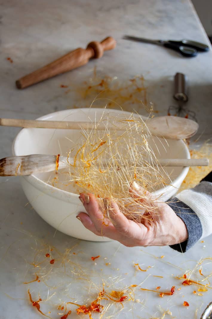 A ball of spun sugar being formed by hand.