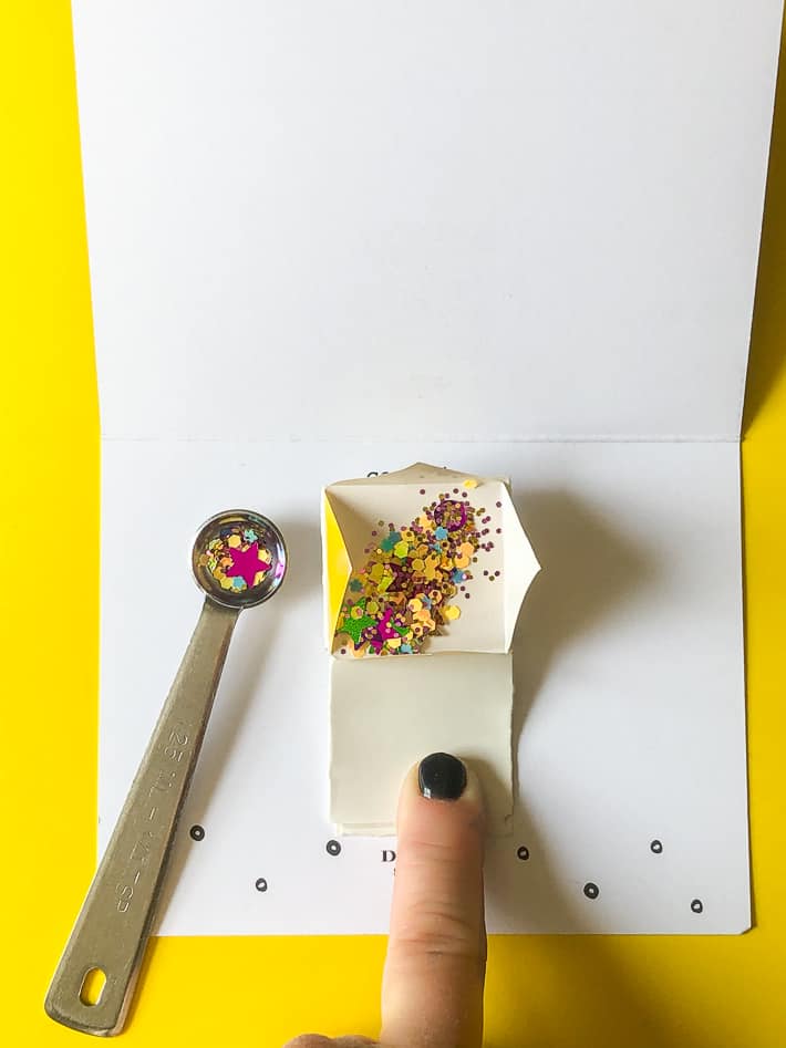 Filling glitter bomb mechanism with confetti and glitter