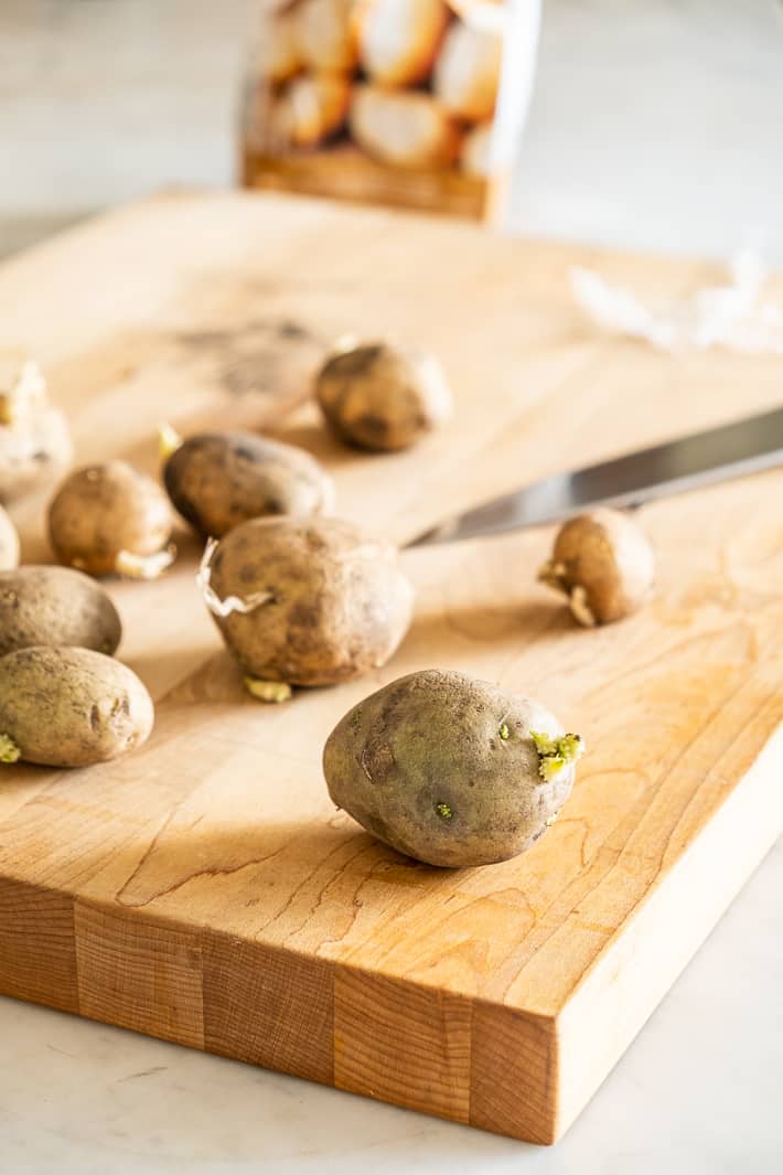 Seed potatoes on a wood butcher block ready for splitting.