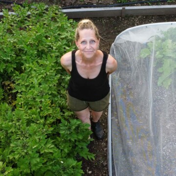 Karen Bertelsen stands in her large community vegetable garden.