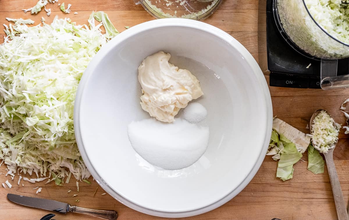 White ironstone bowl with mayo, sugar and salt added to it.