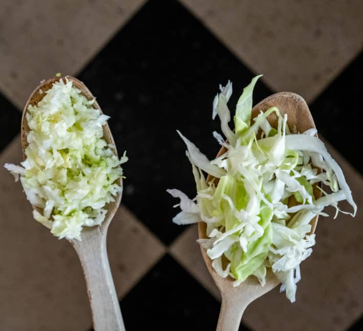 Side by side wooden spoons showcasing food processed shredded cabbage compared to hand shredded.