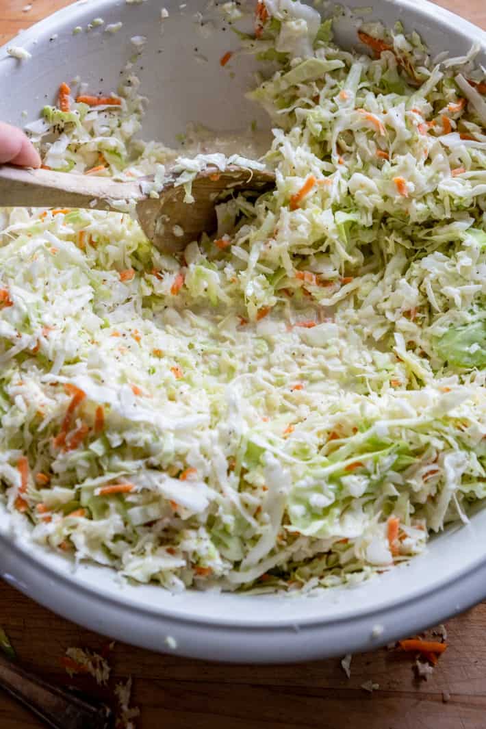 Mixing slaw mixture into creamy dressing.