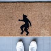 DIY demon Halloween doormat seen from above with 2 feet.