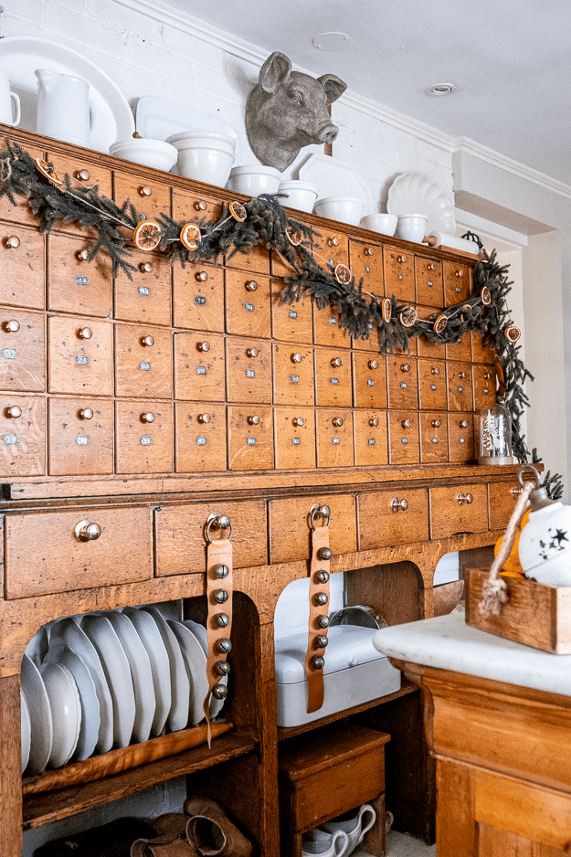 Antique hardware cabinet with sleigh bells and garland