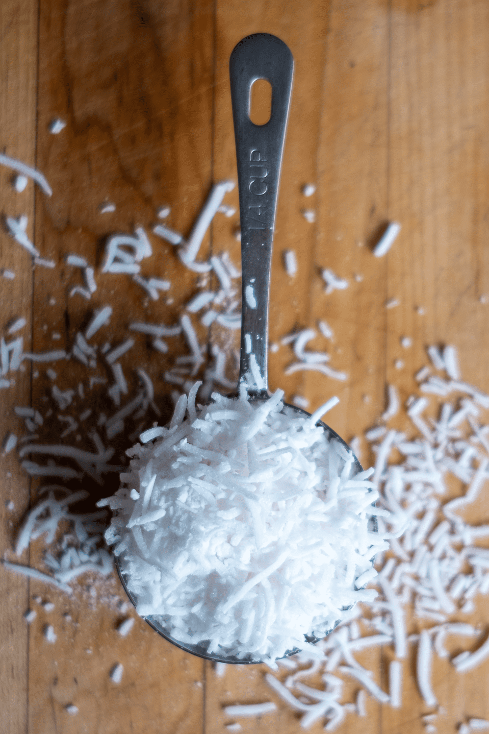 Shredded coconut in a measuring cup.