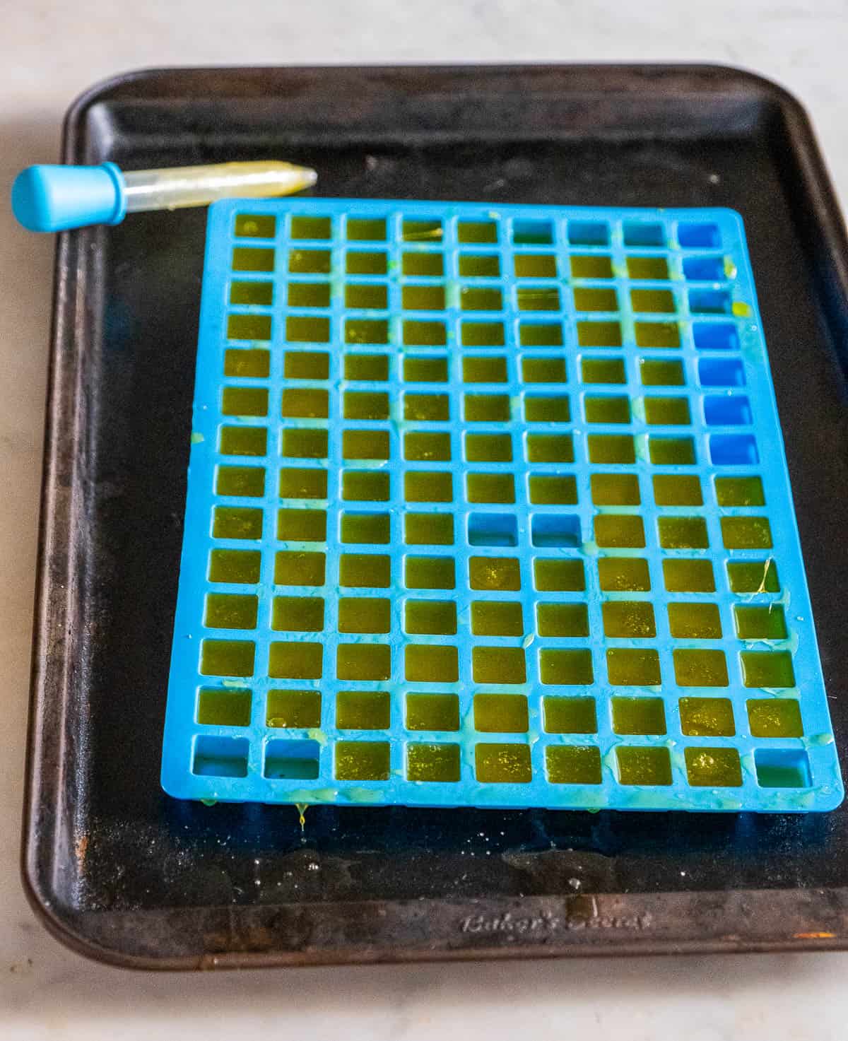 Blue silicone gummy mold filled with newly made cannabis gummies.