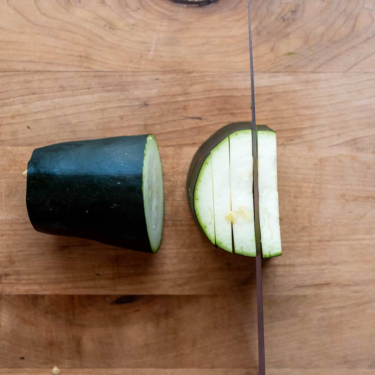 Zuccini chunk being sliced.