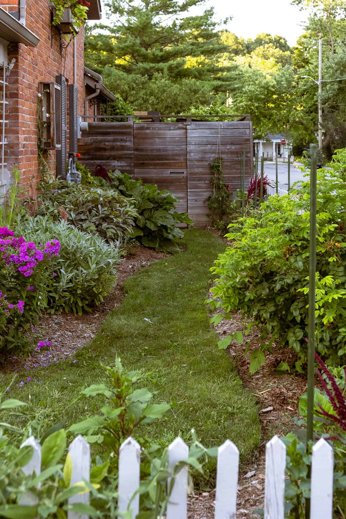 English cottage garden behind white picket fence.